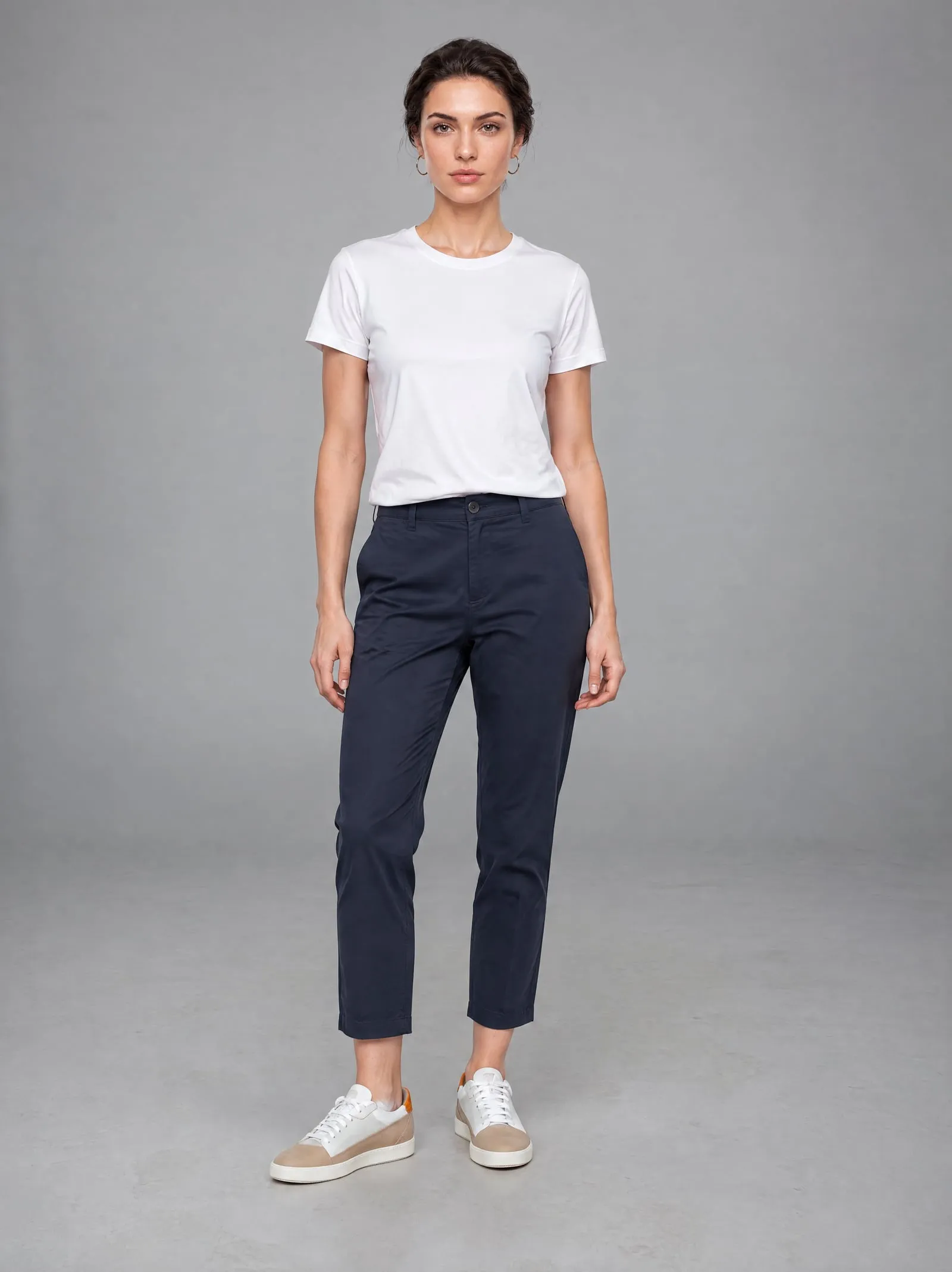 Iris wearing the sand suede court sneakers, standing, in a grey studio