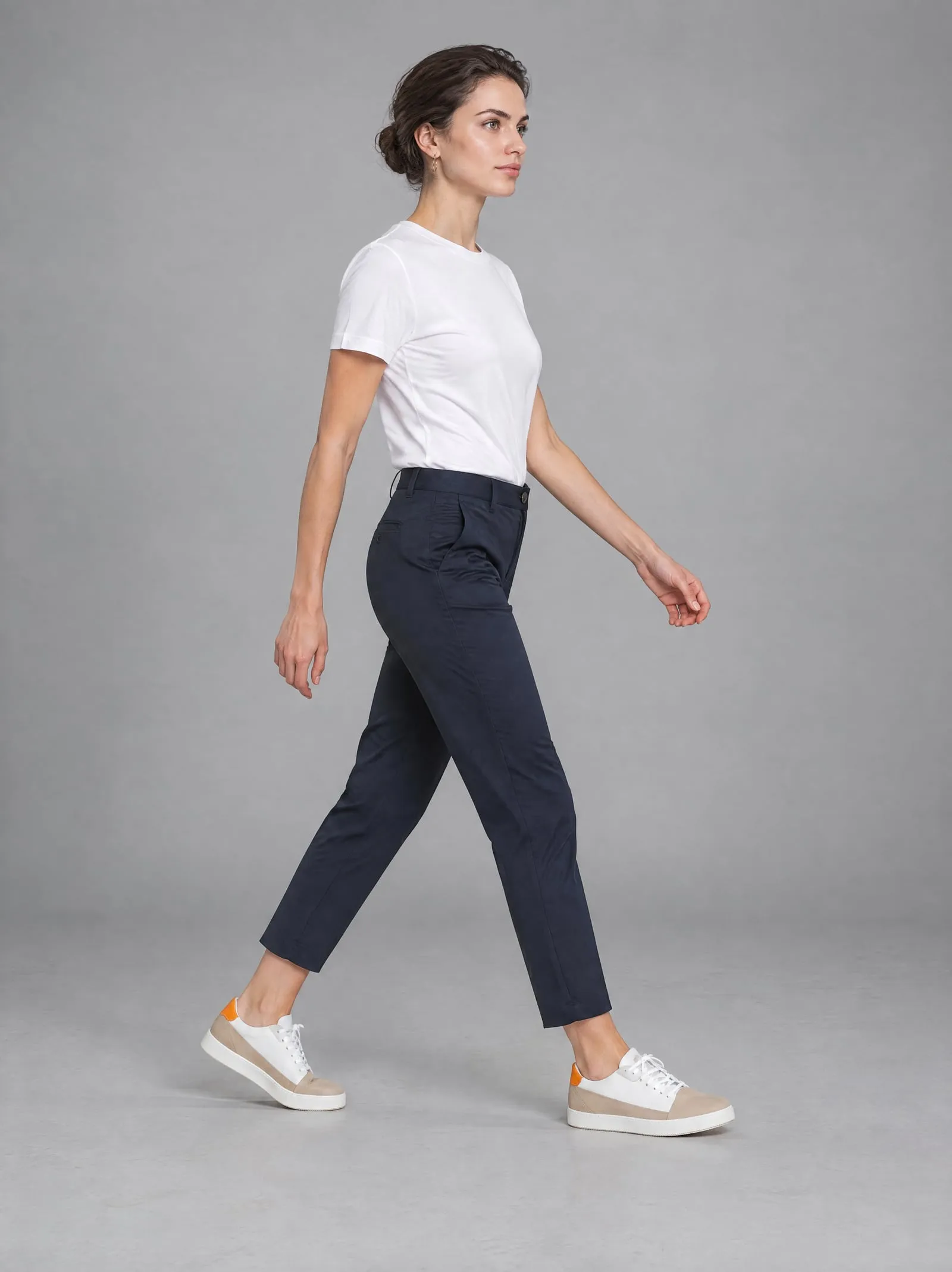Iris wearing the sand suede court sneakers, walking, in a grey studio