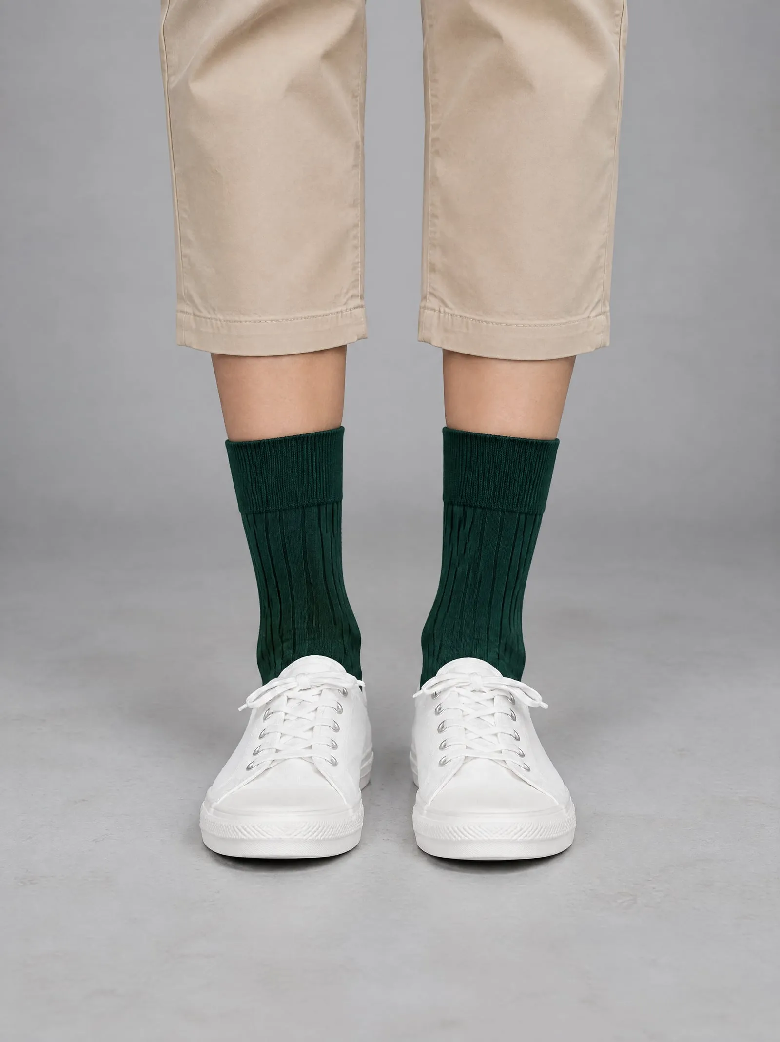 Lena wearing the forest green ribbed socks, close up, facing the camera, in a grey studio
