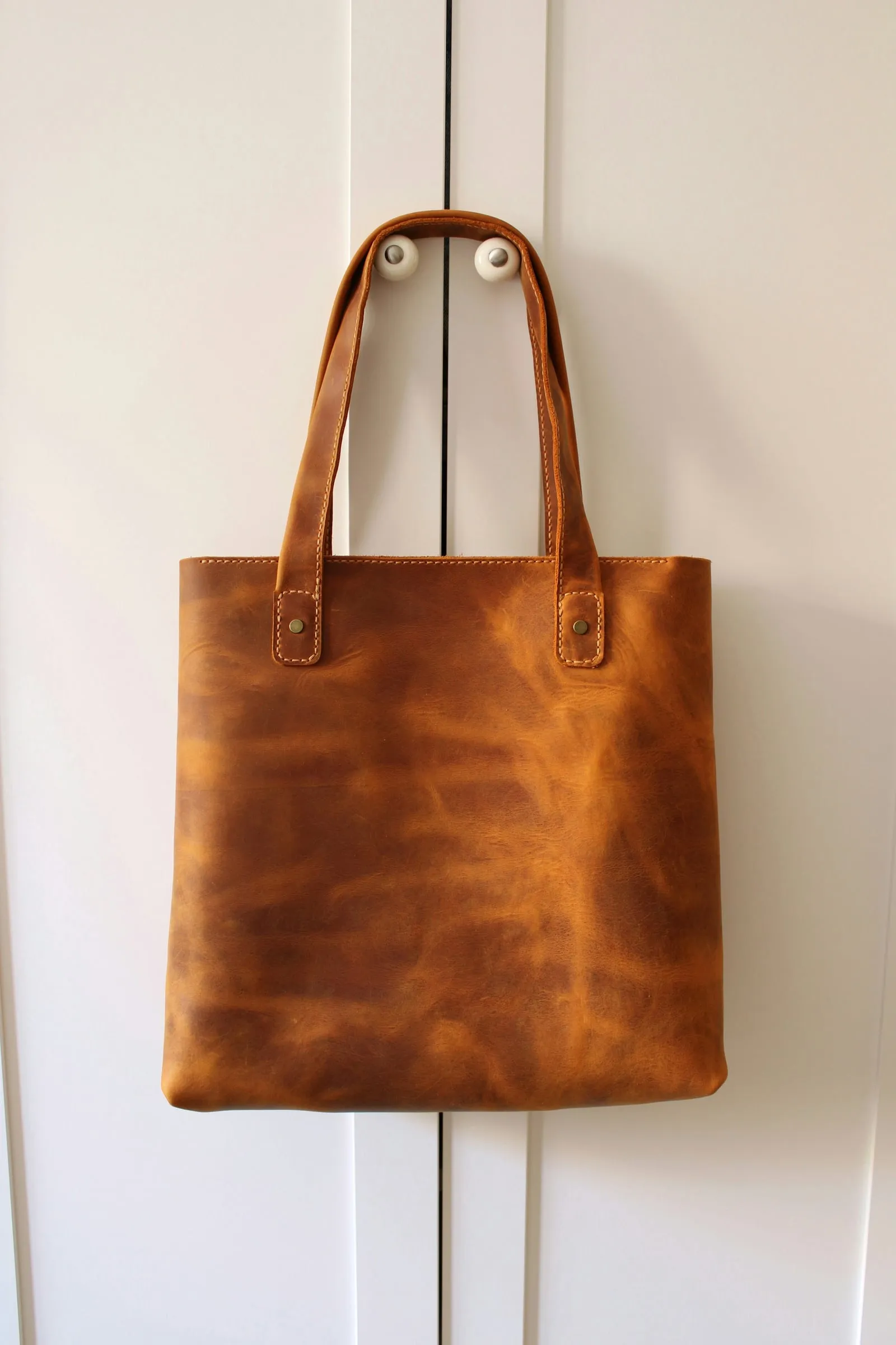 The tan leather tote bag, photographed on its own